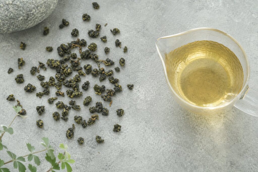 散落在石板上的烏龍茶葉與一壺茶湯